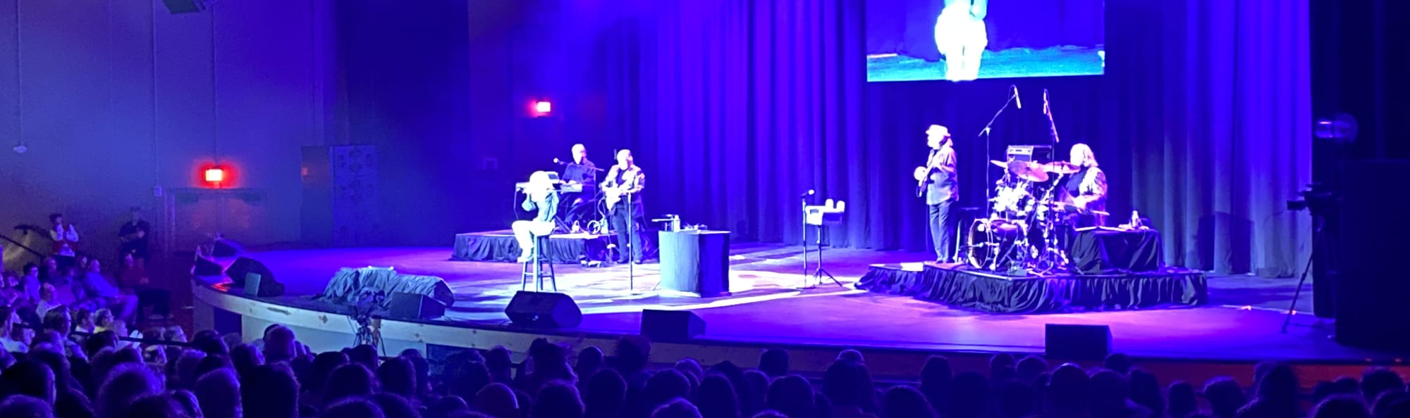 signer on stage in chair washed out by the lights Winston-Salem